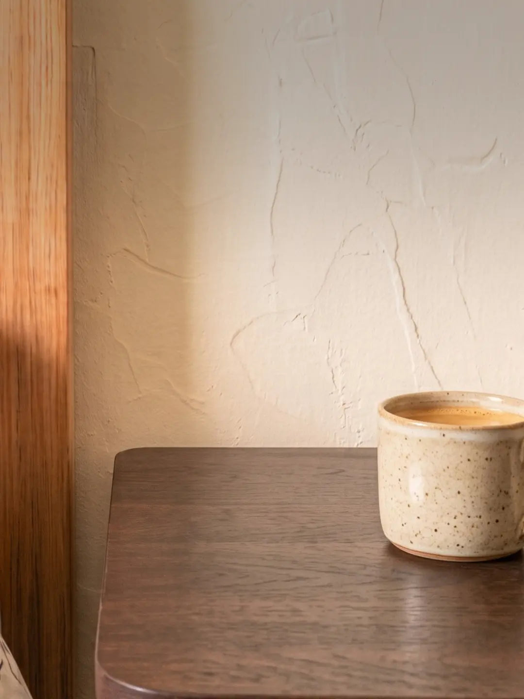 Calm bedside table by a plaster wall, showing Islamic bedroom decor ideas for keeping a TAKVA Mini close at night (mobile copy)