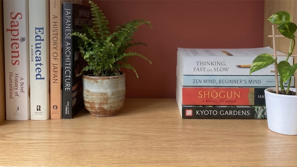 Cosy bookshelf with books and potted plants, showing Muslim home decor ideas for placing a TAKVA Mini among your books